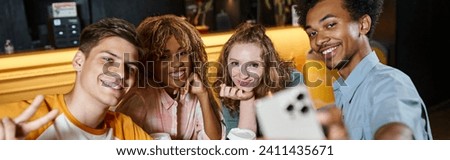 happy african american student taking selfie with trendy multicultural mates in hostel lobby, banner Royalty-Free Stock Photo #2411435671