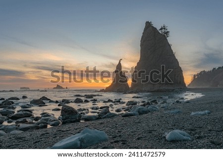 Capture the dramatic sunset along the untamed Olympic National Park coastline, where rugged cliffs meet the Pacific Ocean's beauty Royalty-Free Stock Photo #2411472579