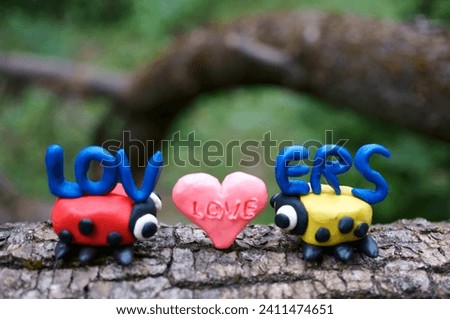 Two ladybugs and the inscription lovers. Romantic relationships. Couple. Valentine's Day. Royalty-Free Stock Photo #2411474651