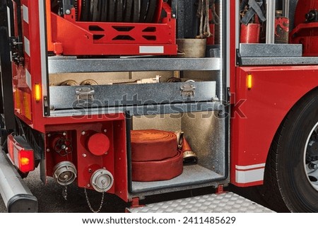Close-up of essential firefighting equipment on a modern firetruck, showcasing tools and gear ready for emergency response to hazardous fire situations Royalty-Free Stock Photo #2411485629