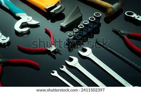 Set of mechanic tools on dark background. Chrome wrenches or spanners, hexagon socket, end cutter pliers, locking pliers, pincers, feeler gauge, bent wrench and hammer. Chrome vanadium spanner wrench. Royalty-Free Stock Photo #2411502397
