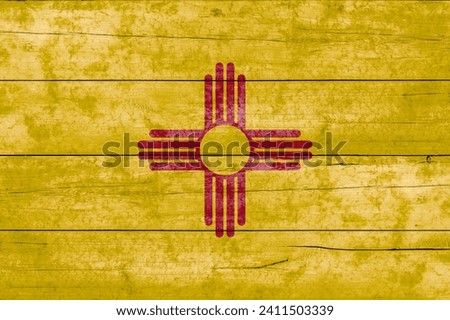 New Mexico State flag on a wooden surface. Banner of the grunge New Mexico State flag. 