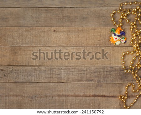 Gold Mardi Gras Beads with Court Jester on Rustic Brown Wood Background with room or space for copy, text, your words.  Above looking down horizontal