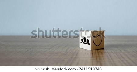 Shield and people group icons on wooden block cubes on white background. Health and life group of employee insurance concept
