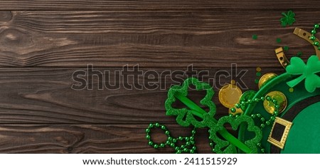 Irish Charm Scene: Capture spirit of St. Paddy's with this top view of traditional elements – leprechaun's hat, party glasses, lucky horseshoe, coins, trefoils, confetti, beads. Ready for celebration