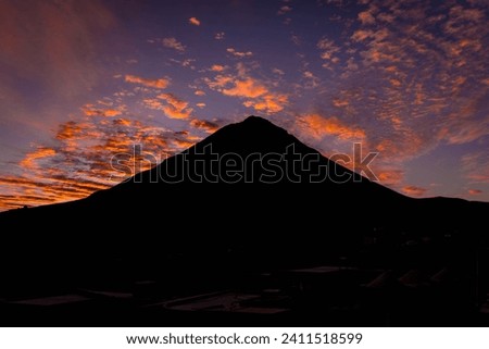 The silhouette of Pico do Fogo volcano and colorful clouds during the scenic sunrise at Fogo island, Cape Verde.
