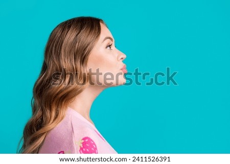 Side profile photo of young coquette girlfriend plump lips sending air kiss empty space learning flirt isolated on blue color background Royalty-Free Stock Photo #2411526391