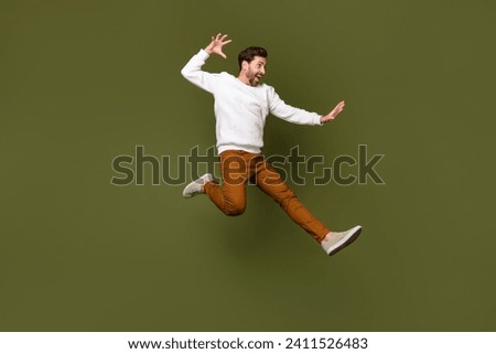 Full length photo of attractive cheerful guy wearing trendy clothes fighting empty space isolated on khaki color background Royalty-Free Stock Photo #2411526483