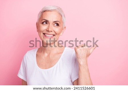Photo portrait of pretty retired female look pointing empty space dressed stylish white outfit isolated on pink color background