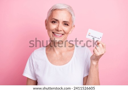 Photo portrait of pretty retired female hold credit card bank client dressed stylish white outfit isolated on pink color background
