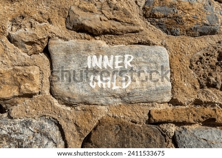 Inner child symbol. Concept words Inner child on beautiful grey stone. Beautiful brown stone wall background. Psychological, motivational inner child concept. Copy space.