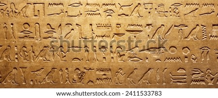 Old Egyptian hieroglyphs on an ancient background. Wide historical and culture background. Ancient Egyptian hieroglyphs as a symbol of the history of the Earth.  Royalty-Free Stock Photo #2411533783