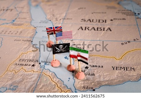 Flags of the United States and Iran and their respective allies surrounding a pirate insignia onto a map of the Red Sea region. It symbolically represents the intricate geopolitical dynamics and Royalty-Free Stock Photo #2411562675