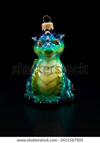 glass Christmas tree toy green dragon close-up on a black background