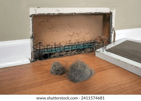 Dirty register wall vent with dust clogging the duct opening in a home Royalty-Free Stock Photo #2411574681