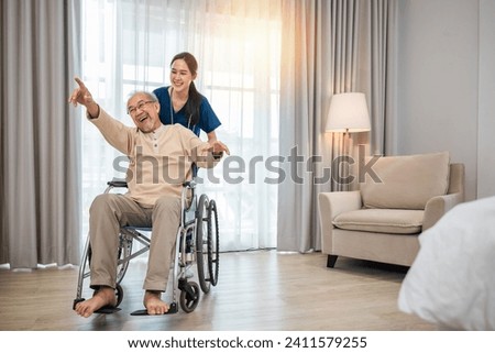 Happy curator person doctor pushing and walk elderly patient freedom raising arm at hospital, Asian senior retired old man sitting on wheelchair having fun with young woman nurse, disabled sanatorium Royalty-Free Stock Photo #2411579255