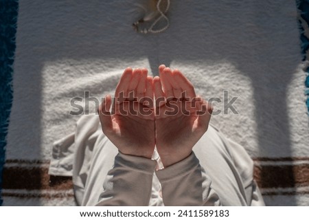 Hand of female muslim praying with mosque interior background during ramadan. Selective focus. Royalty-Free Stock Photo #2411589183