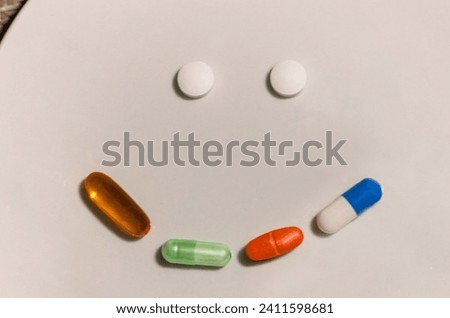 Concept of pills and medications of different colors forming a happy face.