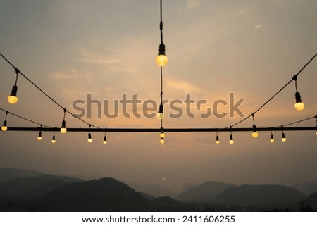 Soft focus of row lightings or lanterns with beautiful dark blue mountain landscape with fog and forest. sunset in mountains at the natural park on evening.