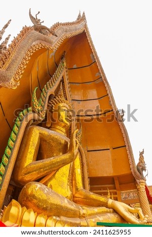Statue of a large golden Buddha in a sitting position at Wat Tham Suea or Tham Suea temple, Kanchanaburi, Thailand