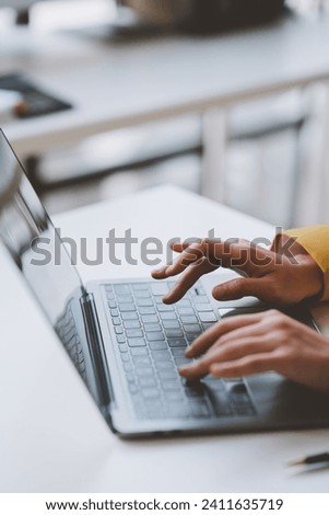 Asian businesswoman, investor, insurance salesperson typing data on earnings graph. Chart showing financial growth in real estate Modern working lifestyle using internet on laptop at table in office. Royalty-Free Stock Photo #2411635719