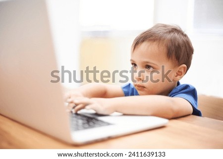 Boy child, laptop and typing in home, reading or search for movie, cartoon or elearning for development. Kid, computer and click keyboard at desk in family house for education, study or online course