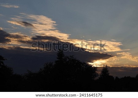 last rays of sunset paint the leading edge of a storm in gold and white Royalty-Free Stock Photo #2411645175