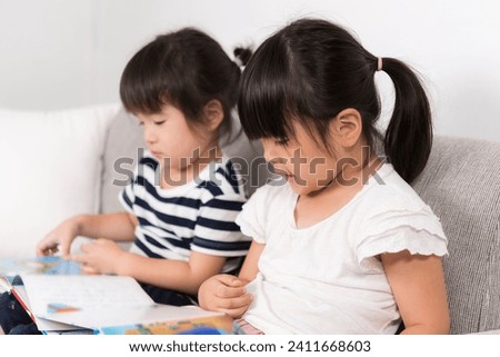 Sisters Reading Picture Books at Home