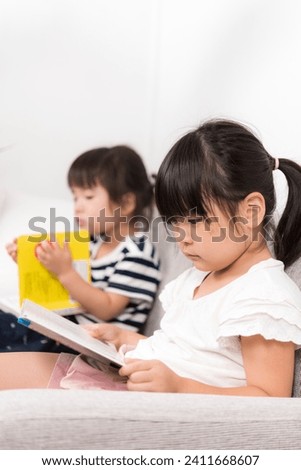 Sisters Reading Picture Books at Home