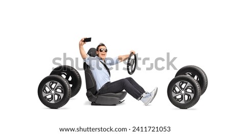 Young man driving and taking a selfie isolated on white background