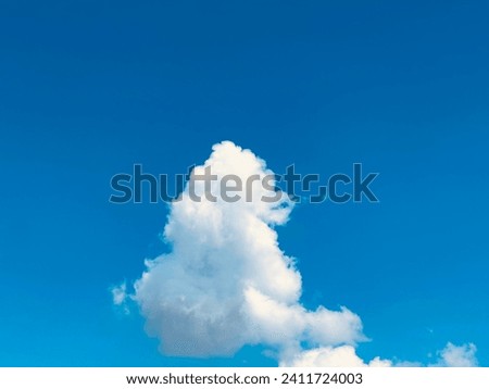A bright blue sky with large white clouds.