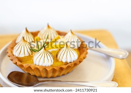 Lemon Tart in white plate on wooden table with copy space.