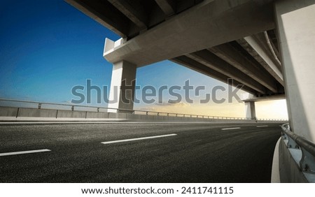 Highway road under the overpass with clear sunset sky.