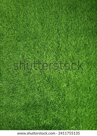 This picture features a smooth and even surface of artificial green grass, which covers the entire frame. The grass has a bright and vibrant color, and a realistic texture.