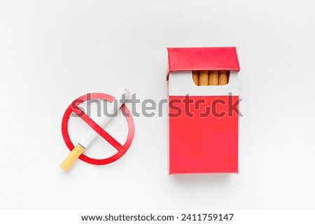 Stop smoking sign beside pack of cigarettes