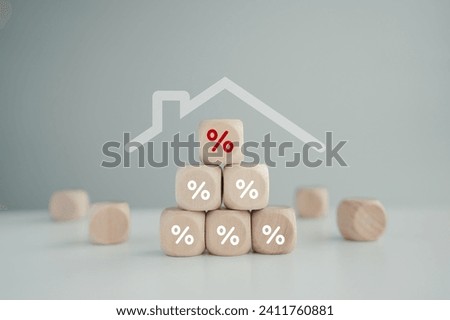 Housing finance concept. Percentage sign on stack of wood block with roof house. Reduce the interest rates of home loan, Mortgage, refinance, repayments, credit limit, house tax and business concept.