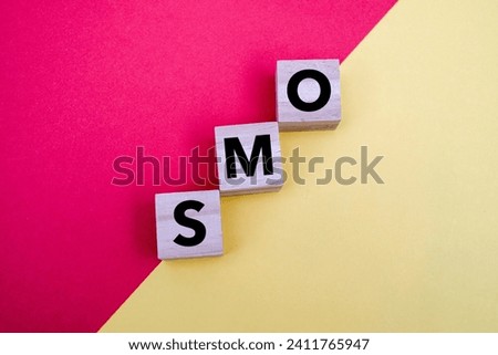A wooden block with word “SMO” on it. SMO stands for "social media optimization". Business and finance concept