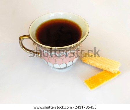 Black coffee on vintage mug and cheese wafer isolated white.