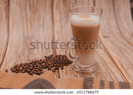 latte coffee on a wooden background next to coffee beans