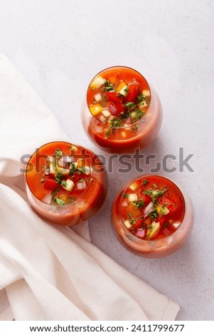Spanish tomato gazpacho cold soup styled and decorated in glasses Royalty-Free Stock Photo #2411799677