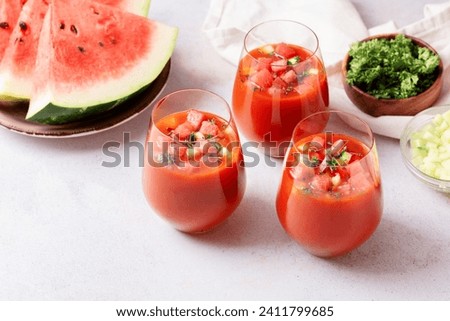 Spanish tomato and watermelon gazpacho cold soup styled and decorated in glasses Royalty-Free Stock Photo #2411799685