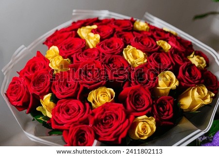 An elegant bouquet of fresh red and yellow roses, symbolizing love and friendship, in a floral arrangement.