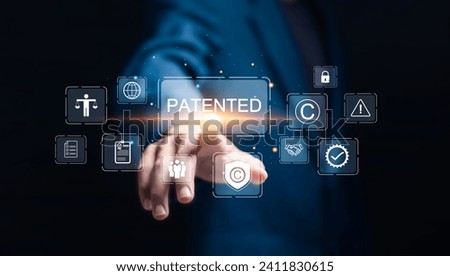 Patented patent copyright law business technology concept. businessman touch virtual screen of patented  word with copyright icons for author rights and patented intellectual property. Royalty-Free Stock Photo #2411830615