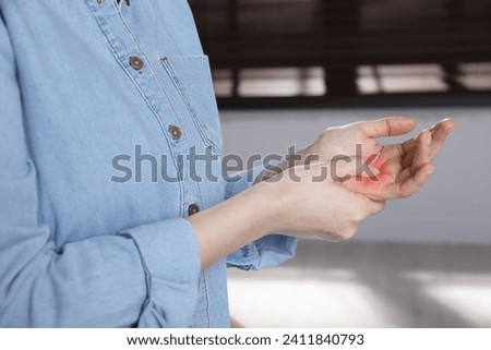 Woman suffering from trigger finger indoors, closeup Royalty-Free Stock Photo #2411840793