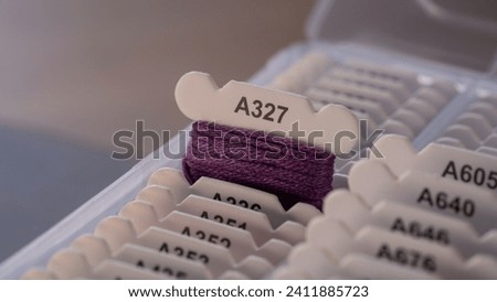 Purple Floss Bobbin with Thread in a Box Royalty-Free Stock Photo #2411885723