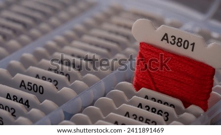 Selective Focus on Red Thread in a Box Against White Background Royalty-Free Stock Photo #2411891469