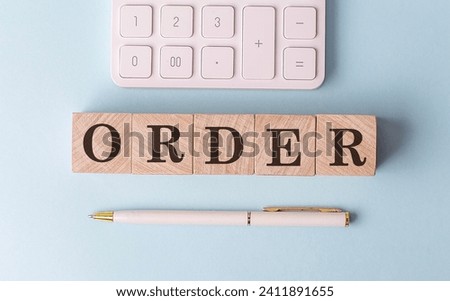 ORDER on a wooden cubes with pen and calculator, financial concept