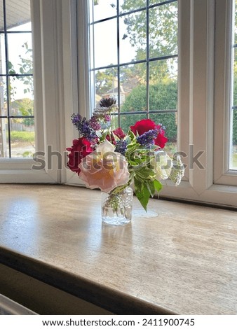 Small bouquet of flowers in a small vase placed by the window