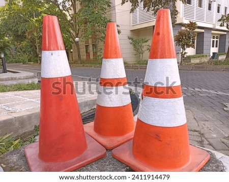 Three orange traffic cones with white stripes
