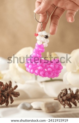 Handmade key chains are unique, small, beautiful and colorful. looks like it is held against an aesthetic background